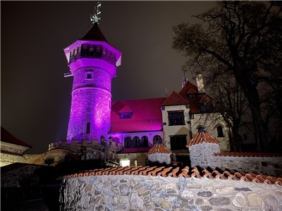 Mostecký hrad Hněvín nasvícený purpurovou barvou v roce 2021