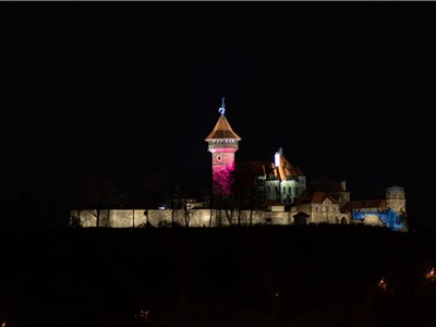 Purpurově nasvícený hrad Hněvín.
