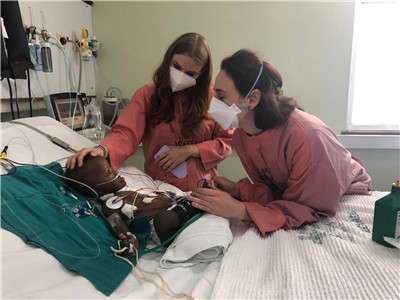 Zdravotní sestry z Bratislavy a malý pacient druhý den po operaci vrozené vady. Děti často krásně komunikují.
